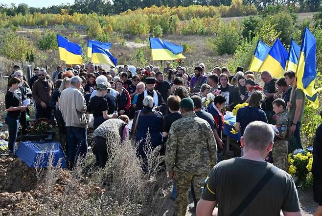 22일(현지시간) 우크라이나 하르키우 인근 묘지에서 전쟁으로 사망한 병사들의 장례식을 치르는 모습.[이미지출처=AFP·연합뉴스]