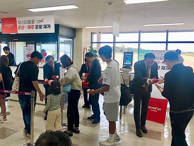 1일 제주공항을 출발하며 군산-제주 노선 운항을 재개한 이스타항공 ZE301편 게이트 앞에서 조중석 이스타항공 대표를 비롯한 임직원들이 승객들에게 선물을 나눠주고 있다. ⓒ이스타항공