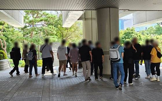 지난달 11일 서울 서초동 서울중앙지법 서관 앞에서 창원간첩단(자통)의 공판기일 변경 사실을 알게 된 지지자들이 단체사진을 찍으러 이동하고 있다. 김정민 기자