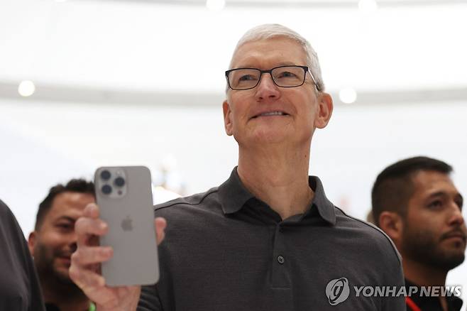 새 아이폰을 들고 있는 팀 쿡 애플 CEO [AFP 연합뉴스 자료사진. 재판매 및 DB 금지]