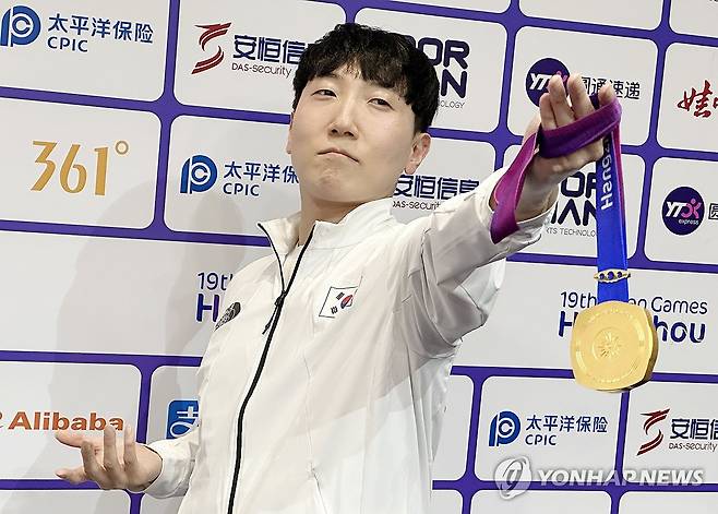 금메달 들어보이는 김관우 (항저우=연합뉴스) 안홍석 기자 = 28일 중국 항저우 e스포츠센터에서 열린 2022 항저우 아시안게임(AG) 스트리트 파이터 V 결승전에서 대만의 샹여우린을 세트 점수 4-3으로 물리치고 금메달을 획득한 뒤 공동취재구역(믹스트존)에서 취재진을 향해 포즈를 취하고 있다. 2023.9.28 ahs@yna.co.kr