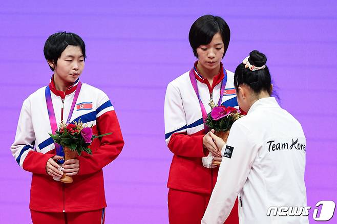 신유빈이 2일 중국 항저우 궁수 캐널 스포츠파크 체육관에서 열린 2022 항저우 아시안게임 탁구 여자 복식 시상식에서 시상대에 오르며 북한 차수영-박수경과 악수하고 있다. 신유빈-전지희 조는 결승에서 북한 차수영-박수경 조를 게임 스코어 4-1(11-6 11-4 10-12 12-10 11-3)로 꺾고 금메달을 차지했다. 이는 2002년 부산 아시안게임 석은미-이은실 이후 21년 만의 아시안게임 여자 복식 금메달이다. 2023.10.2/뉴스1 ⓒ News1 유승관 기자