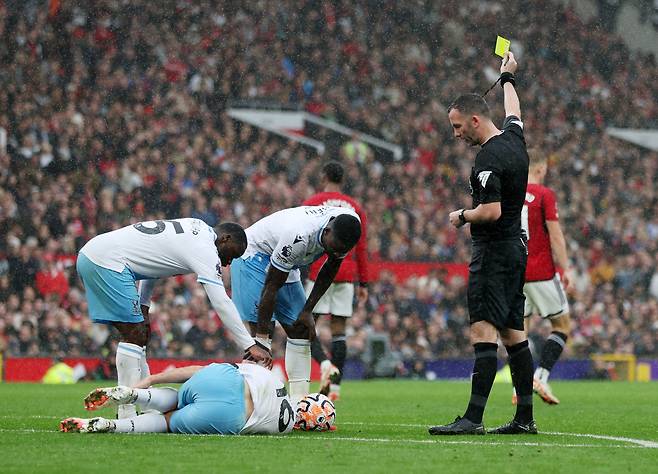 Soccer Football - Premier League - Manchester United v Crystal Palace - Old Trafford, Manchester, Britain - September 30, 2023 Referee Chris Kavanagh shows a yellow card to Manchester United's Mason Mount as Crystal Palace's Joachim Andersen reacts REUTERS/Russell Cheyne NO USE WITH UNAUTHORIZED AUDIO, VIDEO, DATA, FIXTURE LISTS, CLUB/LEAGUE LOGOS OR 'LIVE' SERVICES. ONLINE IN-MATCH USE LIMITED TO 45 IMAGES, NO VIDEO EMULATION. NO USE IN BETTING, GAMES OR SINGLE CLUB/LEAGUE/PLAYER PUBLICATIONS.