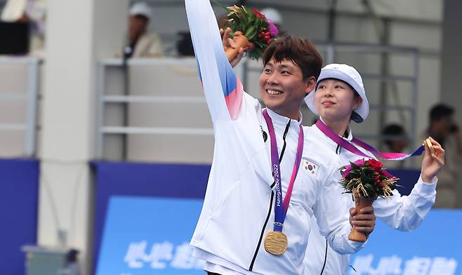 4일 중국 항저우 푸양 인후 스포츠센터에서 열린 2022 항저우 아시안게임 양궁 리커브 혼성전 결승에서 임시현과 이우석이 금메달을 확정짓고 시상식을 마친뒤 이동하고 있다. 사진 | 항저우=연합뉴스