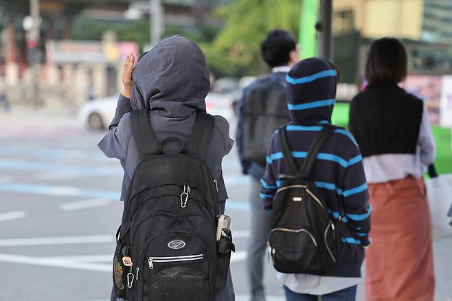 쌀쌀한 가을 날씨를 보인 5일 오전 서울 종로구 광화문네거리에서 외투와 긴 소매 옷을 입은 시민들이 횡단보도 신호를 기다리고 있다.연합뉴스