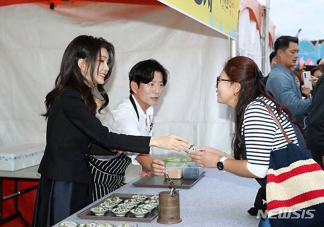 [서귀포=뉴시스] 전신 기자 = 윤석열 대통령 부인 김건희 여사가 6일 서귀포항 동부두 일원에서 열린 제4회 제주 서귀포 은갈치 축제에서 은갈치 회무침을 시민들에게 나눠주고 있다. 2023.10.06. photo1006@newsis.com