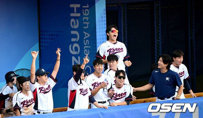 [OSEN=항저우(중국), 최규한 기자] 5일 오후 중국 항저우 사오싱 야구장에서 ‘2022 항저우 아시안게임’ 야구 슈퍼라운드 1차전 한국과 일본의 경기가 열렸다.8회말 2사 2루 상황 한국 노시환이 달아나는 1타점 적시타를 날리고 1루에 안착했다. 노시환을 향해 환호하는 한국 더그아웃. 2023.10.05 / dreamer@osen.co.kr