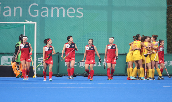 The Korean women's hockey team, left, reacts after conceding a goal during the final at the Hangzhou Asian Games against China held at Gongshu Canal Sports Park Stadium in Hangzhou, China on Saturday. [YONHAP]