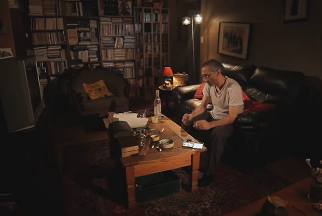 이란계 캐나다인 마즈덱 태비 감독이 2015년 연출한 영화 ‘눈먼 부엉이’의 한 장면. 감독의 개인 홈페이지(mazdaktaebi.com)에서 제약없이 선명한 화질로 무료 관람 가능합니다(영어 자막). 헤다야트가 이 소설을 쓸 때는 없었던 TV가 등장한다는 점, 침대가 아닌 검은 소파가 놓여 있다는 점 등 현대적으로 변용된 부분이 있습니다. [마즈덱 태비 홈페이지 캡처]