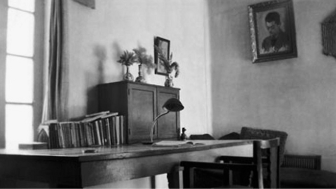 사데크 헤다야트가 사용하던 책상. 그의 사후에 찍은 사진입니다. 벽에는 그의 초상화 한 점이 걸려 있습니다. [사데크 헤다야트 재단·Wikimedia Commons]