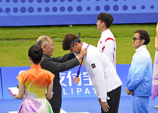 정의선 현대자동차그룹 회장(대한양궁협회장)이 중국 항저우 아시안게임에서 금메달을 딴 이우석 선수에게 메달을 걸어주고 있다. 대한양궁협회 제공