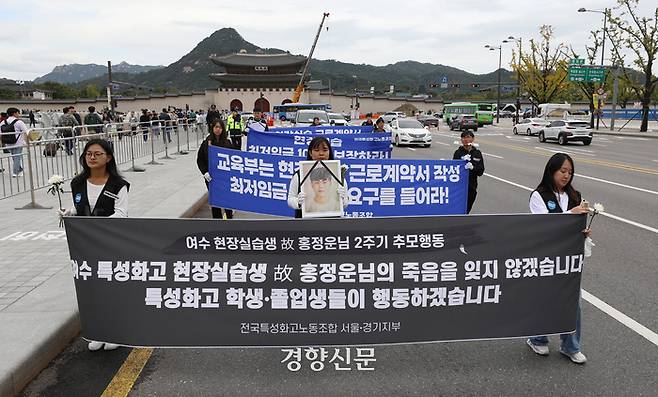 추모행동 참석자들이 홍군의 영정사진과 현수막을 들고 시청으로 행진하고 있다.