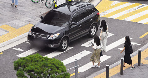 서울 용산구의 한 교차로에서 시민들이 횡단보도를 건너는 도중 차량이 행인을 무시한채 횡단보도를 지나고 있다. [사진은 본 기사와 관련 없음. 헤럴드DB]