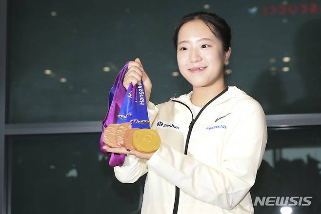 [인천공항=뉴시스] 김근수 기자 = 2022 항저우 아시안게임 대한민국 여자 탁구 대표팀 신유빈이 8일 인천국제공항 제1여객터미널 입국장에서 열린 환영행사에서 메달을 들어 보이고 있다. 2023.10.08. ks@newsis.com