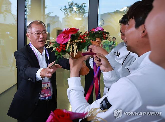 '금메달은 자네들이!' (항저우=연합뉴스) 홍해인기자 = 6일 중국 항저우 푸양 인후 스포츠센터에서 열린 2022 항저우 아시안게임 양궁 리커브 남자 단체전 결승, 인도와의 경기에서 금메달을 획득한 오진혁, 이우석, 김제덕이 시상식 뒤 격려 차 방문한 정의선 현대차 회장에게 금메달을 걸어주려다 정 회장이 이를 만류하고 있다. 2023.10.6 hihong@yna.co.kr