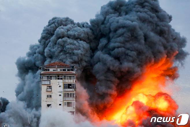 지난 7일(현지시간) 팔레스타인 무장 정파 하마스의 이스라엘 공격으로 가지 지구에 있는 고층 타워가 불길과 검은 연기에 덮인 모습이 보인다. 2023.10.9 ⓒ 로이터=뉴스1 ⓒ News1 우동명 기자