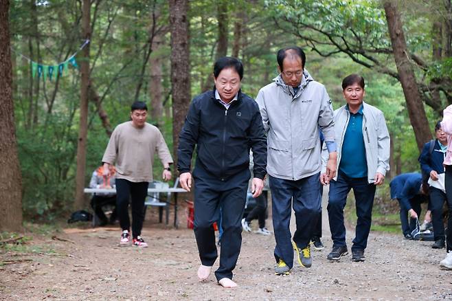 온대 활엽수 극상림을 이룬 광릉숲을 맨발로 걷고 있는 주광덕 시장. / 사진제공=성남시