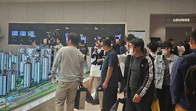 트리우스 광명 모델하우스 내에 설치된 모형도를 감상하는 예비 청약자들. 사진=대우건설