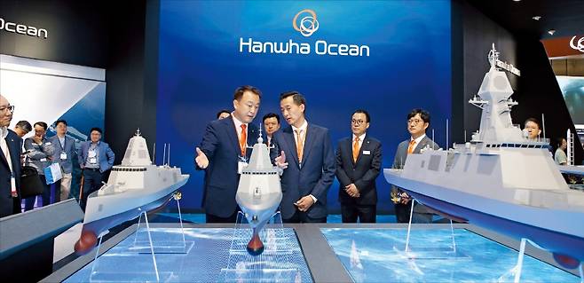 김동관 한화그룹 부회장(앞줄 오른쪽)이 국제해양방위산업전에서 한화오션 부스를 방문해 전시된 수상함을 둘러보며 설명을 듣고 있다. /한화 제공