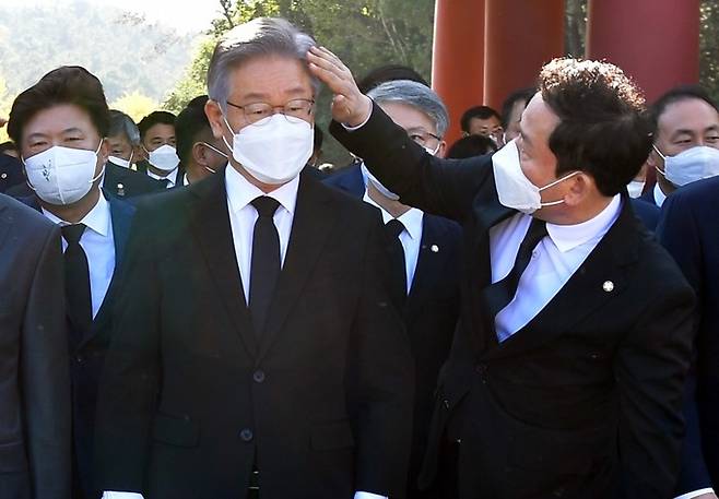 2021년 10월22일 광주 북구 운정동&nbsp;국립5·18민주묘지를 방문한 당시 더불어민주당 대선 후보이던 이재명 대표의 머리를 광주시당위원장이던 송갑석 의원(오른쪽)이 손질해주고 있다. 광주=뉴시스