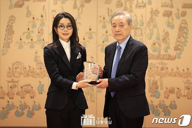 윤석열 대통령 부인 김건희 여사가 12일 서울 용산 대통령실 청사에서 이민혁 대한암협회 회장으로부터 대한암협회 명예회장 추대패를 받은 뒤 기념촬영하고 있다.(대통령실 제공)