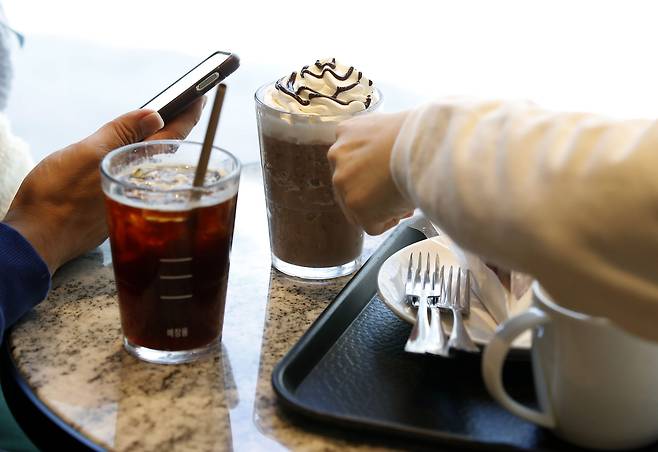 서울 도심의 한 카페에서 시민들이 음료를 테이블에 놓고 있다. /뉴스1