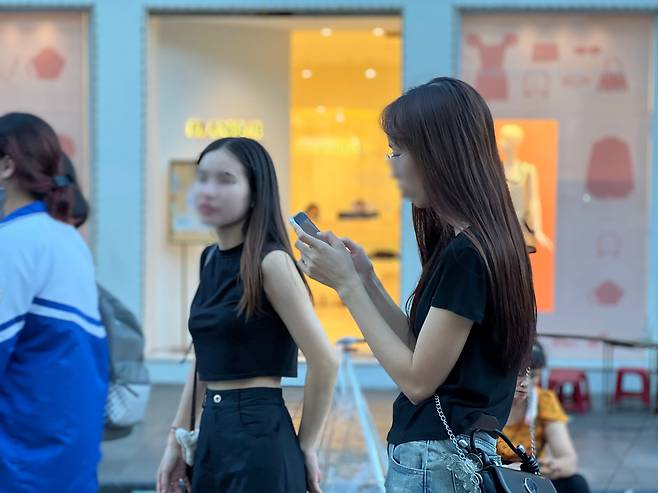 하노이의 대표적 쇼핑 거리인 장띠엔 거리를 걷는 베트남 젊은이들. /김은영 기자