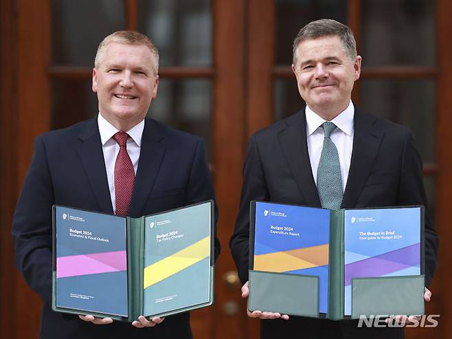 [더블린=AP/뉴시스] 아일랜드가 다국적 정보기술(IT)회사와 제약회사로부터 거둔 세금으로 복지서비스 운영을 위한 기금을 만든다고 10일(현지시간) 미국 월스트리트저널(WSJ)이 보도했다. 사진은 마이클 맥그래스 재무장관(왼쪽)과 파스칼 도노회 공공지출장관(오른쪽)이 지난 10일 아일랜드 더블린 렌스터하우스 앞에 서 있는 모습. 2023.10.12.