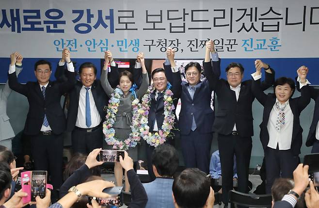 더불어민주당 진교훈 강서구청장 보궐선거 후보가 11일 오후 강서구 마곡동 캠프사무실에서 당선이 확실시되자 당 지도부와 함께 손 들어 인사하고 있다. 연합뉴스