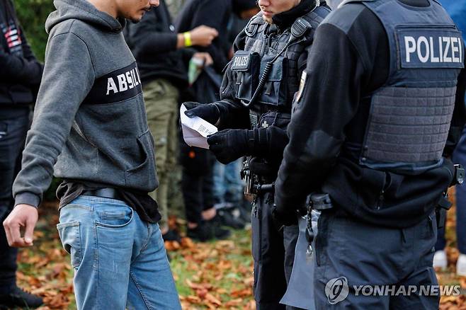 독일-폴란드 국경 경비 도중 이주자 서류 점검하는 독일 경찰 [AFP 연합뉴스 자료사진. 재판매 및 DB 금지]