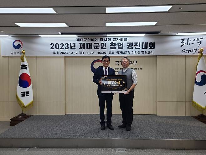 김진수 국가보훈부 제대군인국장(왼쪽)이 12일 오후 세종 청사에서 '2023년 제대군인 창업 경진대회' 최우수상 수상자 조일현 예비역 육군 소령에게 상장을 전달하고 있다.(국가보훈부 제공)