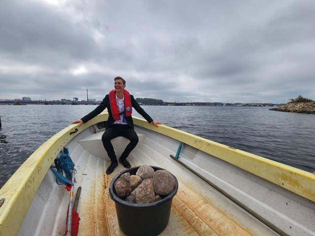 레세 프리만 옌슨 올보르 시장이 주민들로부터 기부받은 돌을 던지기 위해 보트를 타고 림 피오르드 안으로 이동하고 있다. 올보르(덴마크)=신은별 특파원