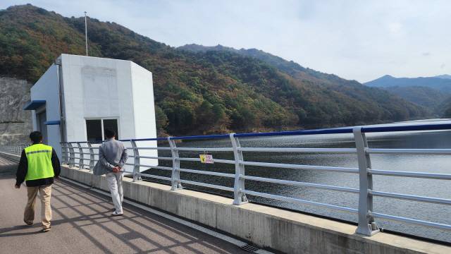 ▲ 13일 양구군 동면 비아리 산1번지 일원 비아댐이 ‘만수위’를 기록하고 있는 가운데 김춘호 양구군상하수도사업소장과 홍상기 수도운영팀장이 시설을 점검하고 있다.