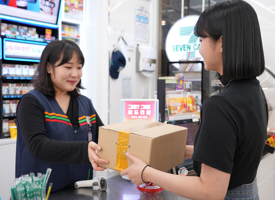 A customer receives her parcel at a convenience store. [7-ELEVEN]