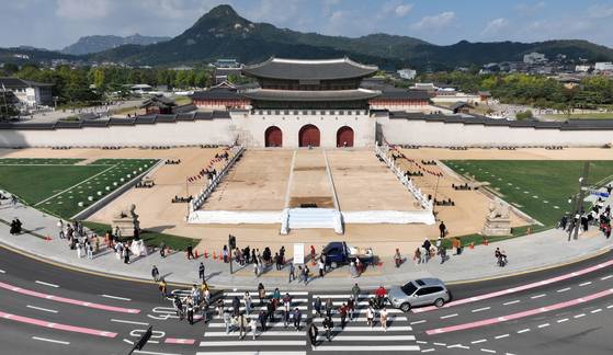 The newly restored woldae, a wide platform that leads up to the Gwanghwamun of Gyeongbok Palace, gets ready to be unveiled to the public on Sunday, together with its new signboard. [YONHAP]
