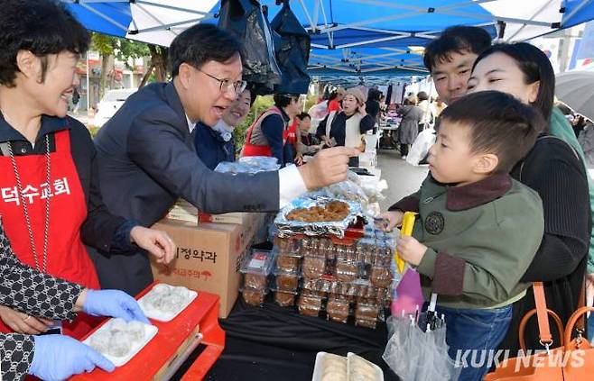 덕수교회 담임 김만진 목사가 꼬마 고객에게 밝은 표정으로 한과를 먹여주고 있다.전과 부침개를 판매한 덕수교회 최재숙(65) 권사는 “우리 부스에서 판매한 음식들은 인기가 좋아 올해도 일찌감치 완판되었다. 판매 수익금을 어려운 이웃을 위해 쓸 생각을 하니 힘든 줄 몰랐다”고 말했다