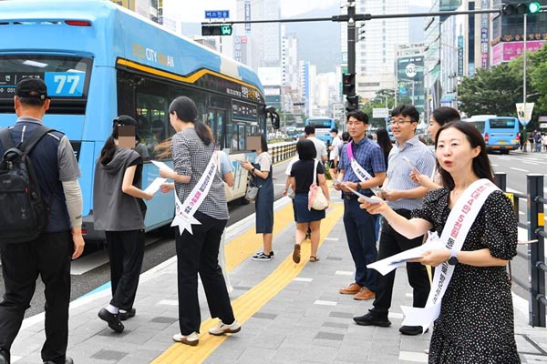 부산시 공무원들이 버스 정류장에서 ‘동백패스’를 홍보하고 있다.  부산시 제공