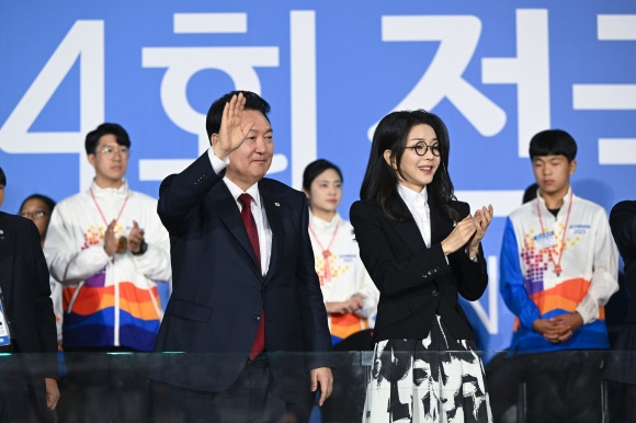 윤석열 대통령과 부인 김건희 여사가 지난 13일 전남 목포종합경기장에서 열린 제104회 전국체육대회 개회식에서 선수단에게 손을 흔들고 있다. 연합뉴스 제공