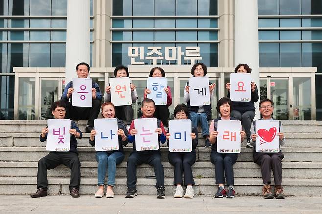 지금까지 2300만원의 장학금을 기부한 전남대 환경관리직 노조원들이 학생을 응원하는 문구를 들어 보이고 있다. /사진제공=전남대학교.