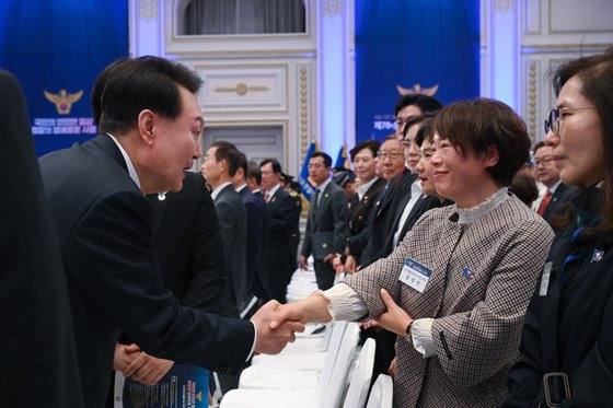 윤석열 대통령이 18일 청와대 영빈관에서 열린 제78주년 경찰의날 기념식에서 경찰영웅 고 이강석 경정의 배우자와 인사하며 격려하고 있다. 대통령실사진기자단