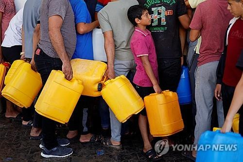 식수 배급 위해 줄 선 팔레스타인 주민들 [로이터 연합뉴스]