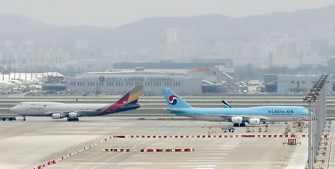 Asiana Airlines and Korean Air planes are parked at Incheon International Airport. (Newsis)