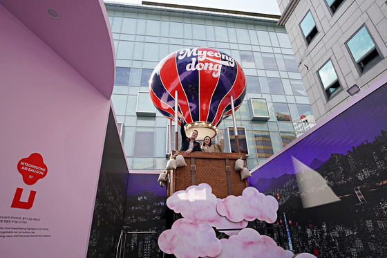 Visitors on the hot air balloon-shaped lift at the rooftop of the LDF House [LOTTE DUTY FREE]