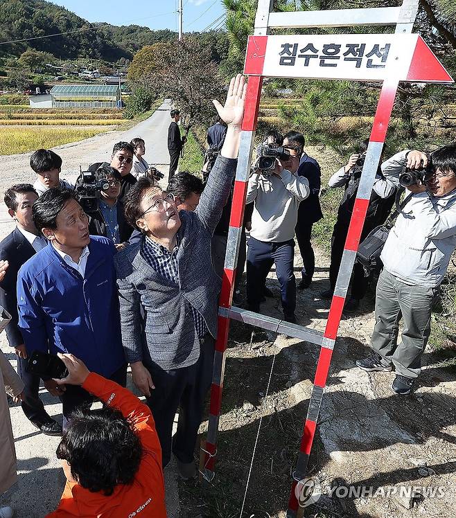 '손도 안 닿네' (예천=연합뉴스) 윤관식 기자 = 더불어민주당 우원식 의원이 20일 경북 예천 은풍면 오류리 한천 집중 호우 피해현장을 찾아 침수흔적선에 손을 대 보고 있다. 2023.10.20 psik@yna.co.kr