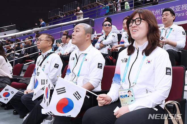 [항저우=뉴시스] 사진공동취재단 = 장미란 문체부 제2차관(오른쪽), 김진혁 선수단장(가운데)이 22일 항저우 궁수 캐널 스포츠파크 체육관에서 열린 2022 항저우 장애인아시아경기대회 탁구 경기에 출전하는 대한민국 선수들을 응원하고 있다. 2023.10.22. photo@newsis.com