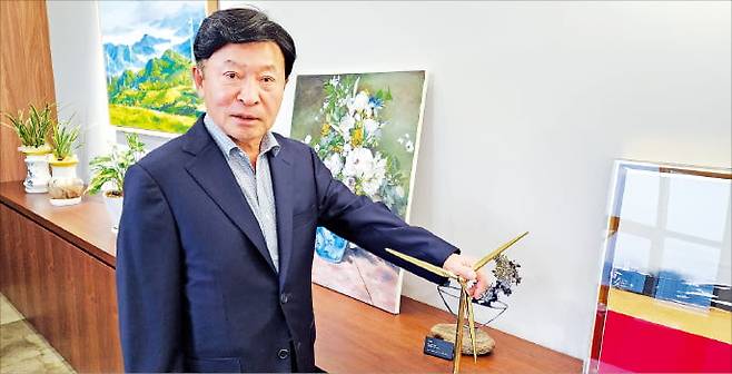 김성권 씨에스윈드 회장이 지난 19일 서울 논현동 집무실에서 풍력발전기 모형을 가리키며 회사 비전을 소개하고 있다.  최형창 기자