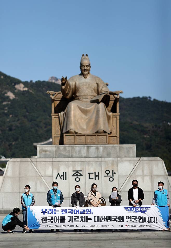 2020년 10월8일 오전 서울 광화문광장에서 열린 ‘한국어 교원의 사회적 지위 보장·처우 개선 촉구 기자회견’에서 민주노총 전국대학노동조합 한국어 교원 조합원들이 관련 내용이 적힌 현수막을 들고 있다. 연합뉴스