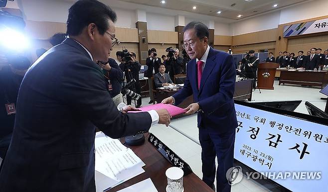 선서문 제출하는 홍준표 대구시장 (대구=연합뉴스) 윤관식 기자 = 홍준표 대구시장(오른쪽)이 23일 대구시청 산격청사에서 열린 국회 행정안전위원회의 대구시에 대한 국정감사에서 국민의힘 김용판 의원에게 선서문을 제출하고 있다. 2023.10.23 psik@yna.co.kr