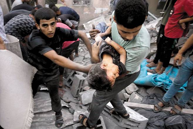 이스라엘·하마스 전쟁 발발 17일째를 맞은 23일 이스라엘과 팔레스타인 사망자가 6500명에 육박했다. 이 가운데 5000여명은 팔레스타인인으로 추정된다. 사진은 지난 18일(현지 시각) 팔레스타인 자치 구역인 가자지구 중부의 한 마을에서 주민이 이스라엘 공습에 의식을 잃은 어린이를 안고 있는 장면이다. /AFP 연합뉴스