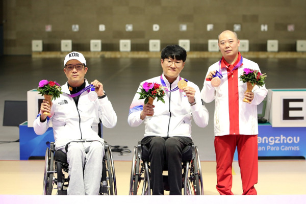 23일 열린 2022 항저우 장애인아시안게임 사격 R1(SH1 남자 10ｍ 공기소총 입사)에서 금메달을 차지한 이장호(가운데)와 은메달을 수확한 박진호(왼쪽). 대한장애인체육회 제공